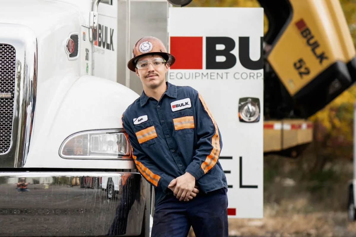 Bulk Equipment Corp technician standing beside a branded Bulk field service truck