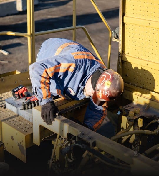 technician repairing a machine on a field service call at a customer site