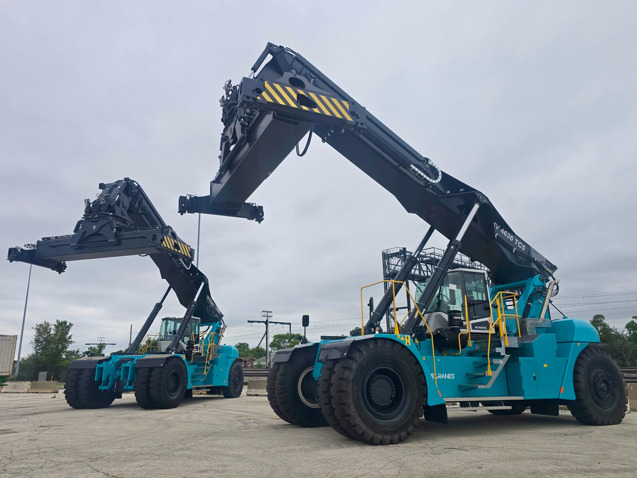 two Konecranes reach stackers with telescopic container spreaders staged in a yard